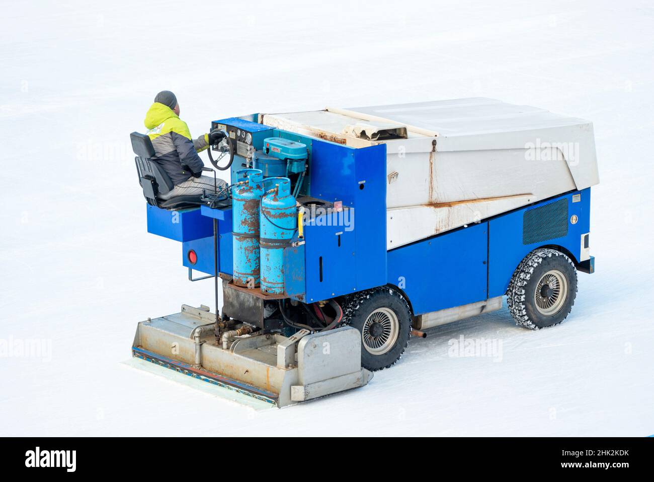 Rear view of old rusty Zamboni ice resurfacer maintaining outdoor ice skating rink Stock Photo
