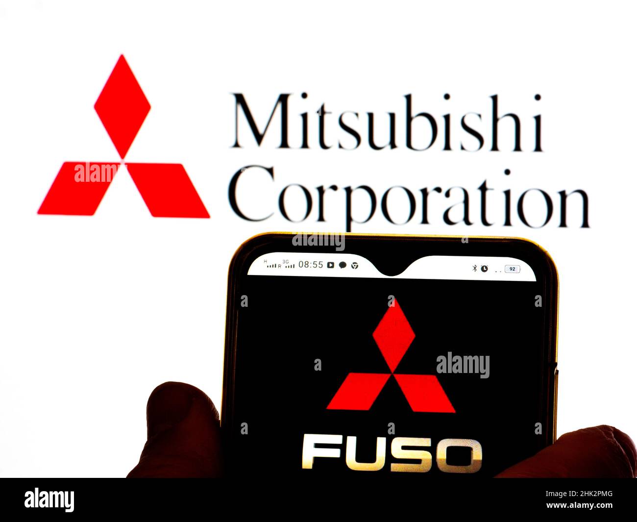 In this photo illustration, the Mitsubishi Fuso Truck and Bus Corporation logo is displayed on a smartphone screen with a Mitsubishi Corporation logo in the background. Stock Photo