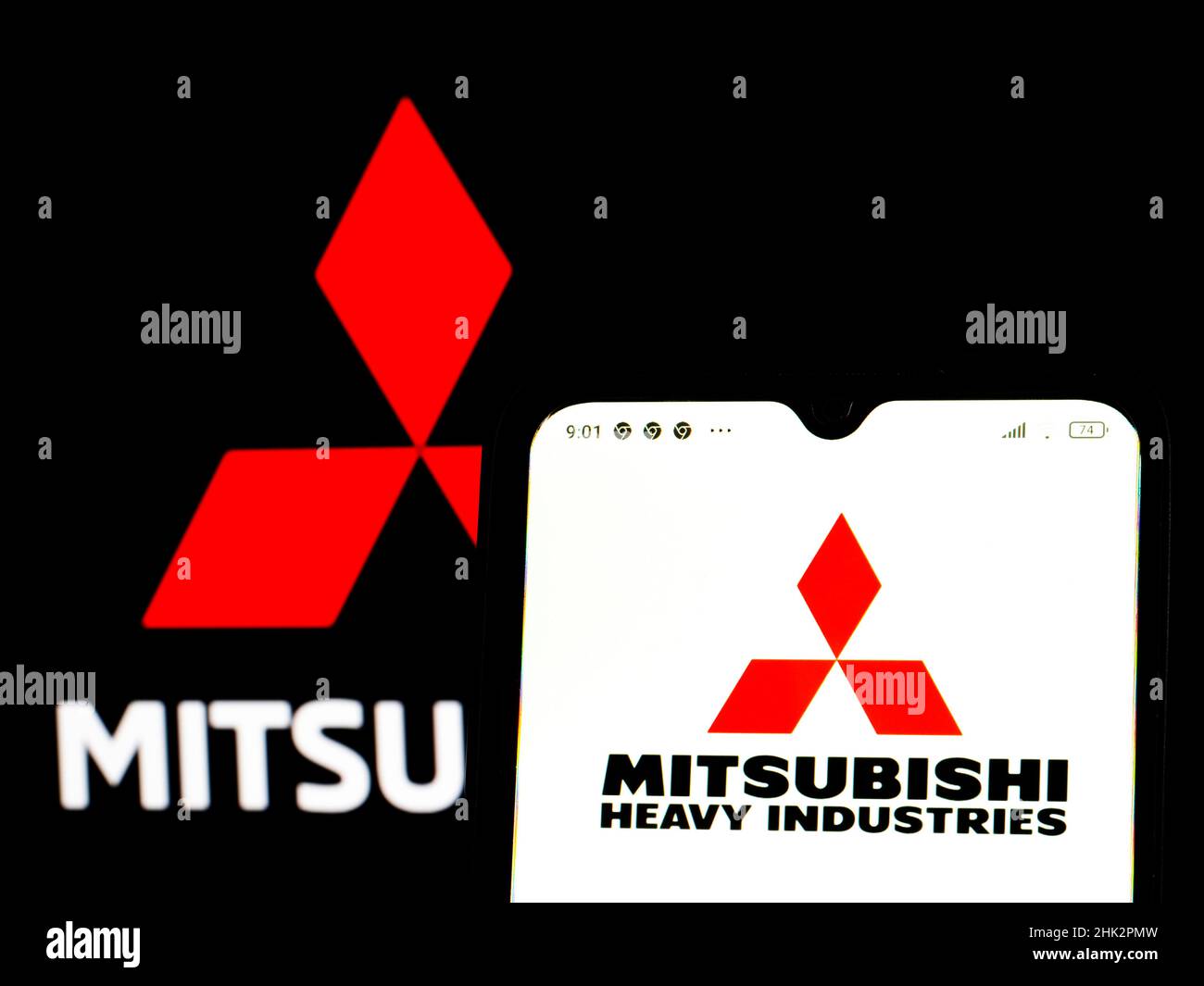 In this photo illustration, the Mitsubishi Heavy Industries logo is displayed on a smartphone screen with a Mitsubishi Corporation logo in the background. Stock Photo