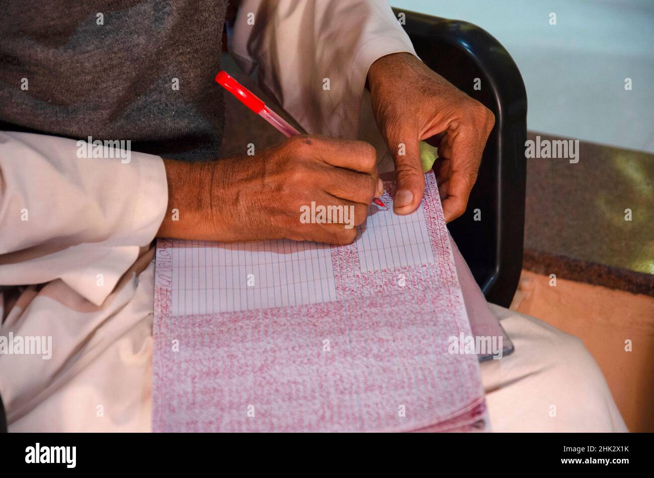 Devotee writing the Lord's name in book inside the temple at Nilkanthdham, Swaminarayan temple, Poicha, Gujarat, India Stock Photo
