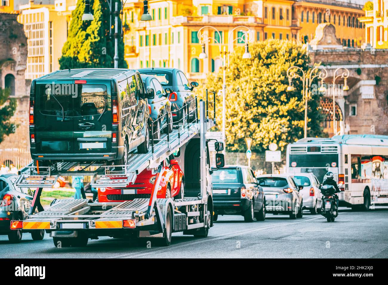 Auto-transport Carrying New Fiat Cars In European City Street. Auto Transport Broker Or Car Transporter. Auto-transport Carrying New Fiat Cars In City Stock Photo