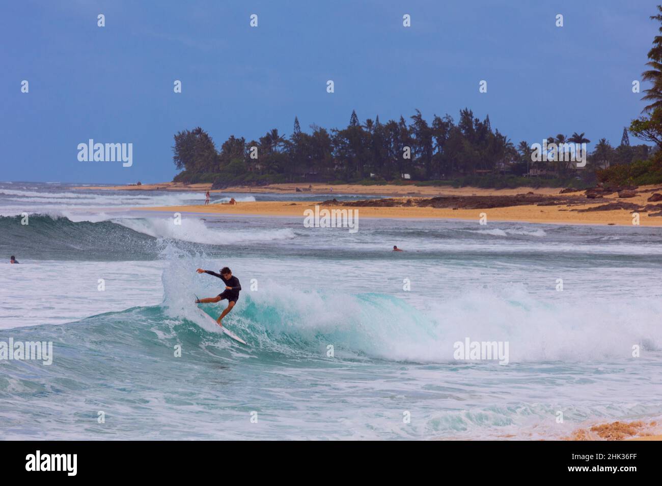 Surfers challenging the breakers at Sunset Beach. North Coast of Oahu. Hawaii. Stock Photo