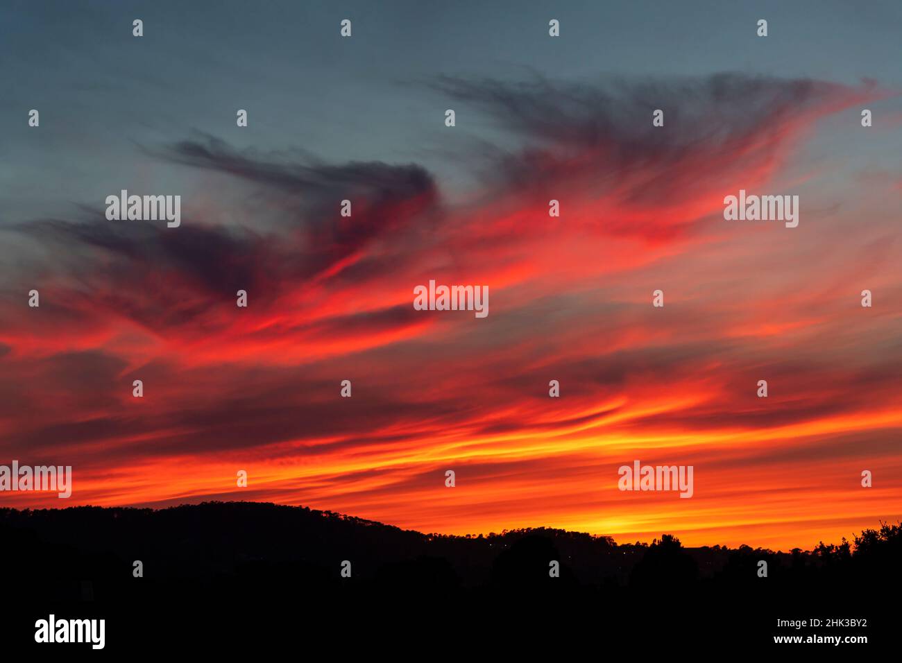 Deep, intense sunset colors in the clouds over the hills in the west ...