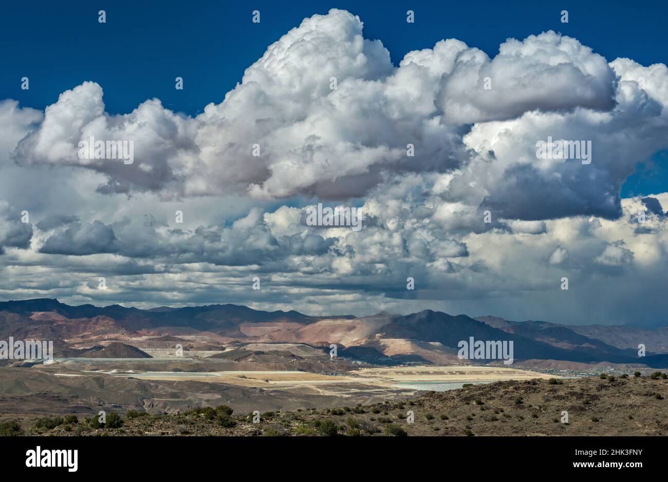 Towering cumulus clouds, rain over Morenci copper mine in far dist 12 m N, White Mountains behind, view from Black Hills, near Clifton, Arizona, USA Stock Photo