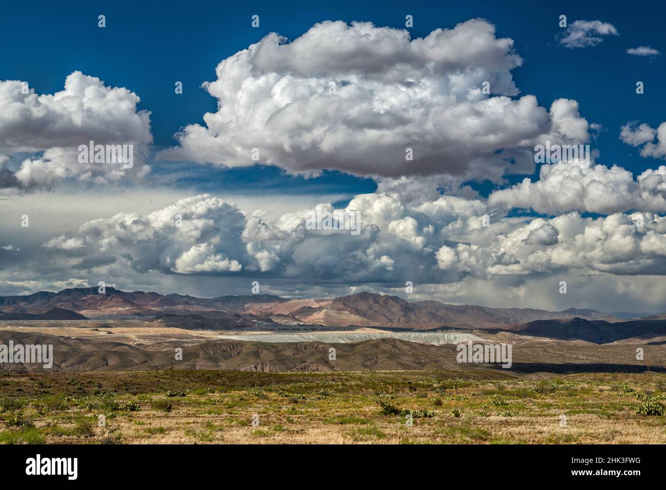 Towering cumulus clouds, rain over Morenci copper mine in far dist 8 m N, White Mountains behind, view from Black Hills, near Clifton, Arizona, USA Stock Photo