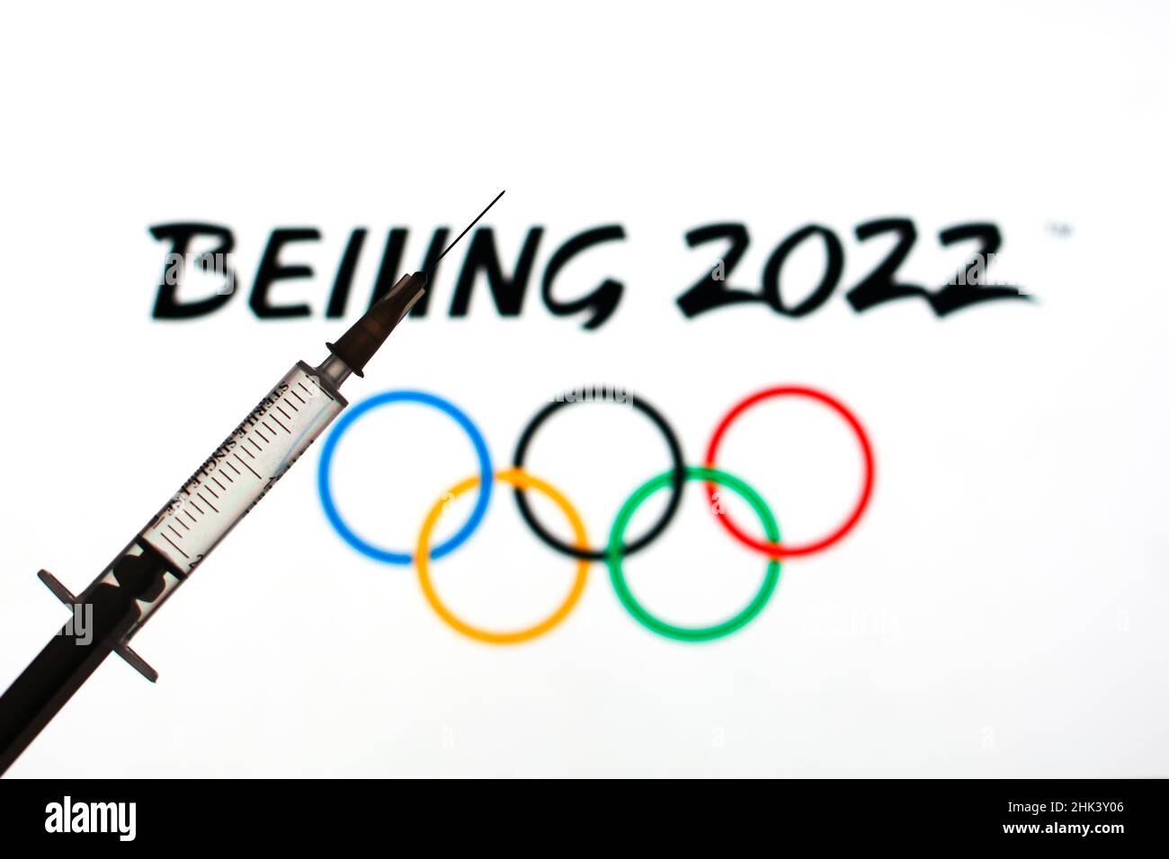 In this photo illustration a medical syringe seen in front of the Beijing winter olympic games logo. Stock Photo