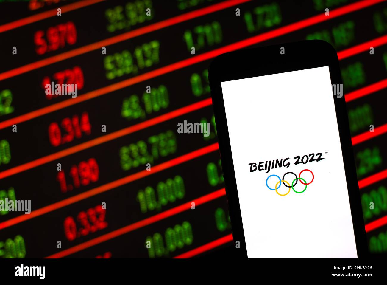In this photo illustration a Beijing 2022 Winter Olympic Games logo logo seen displayed in front of stock market charts. Stock Photo