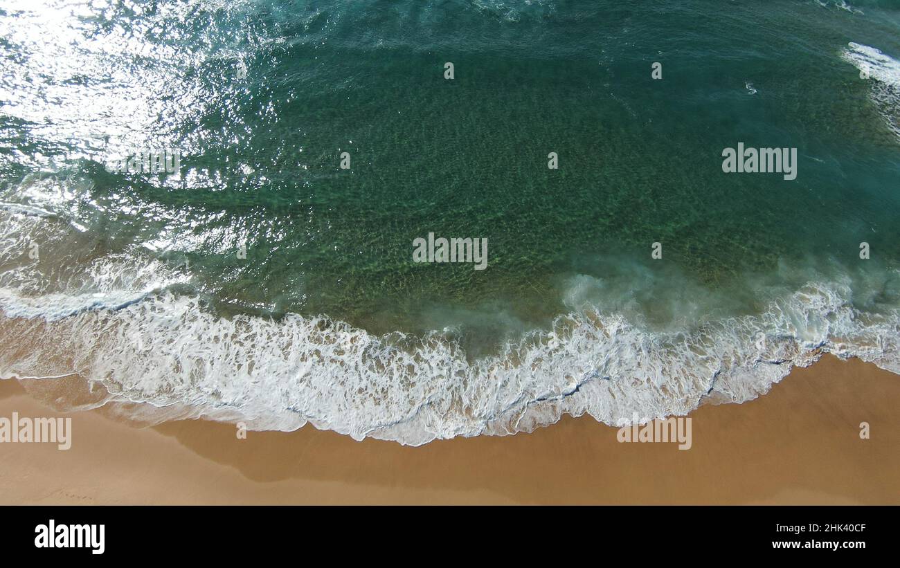 Gangle Wave Gentle wave rolling in on pristine sandy beach Stock Photo - Alamy