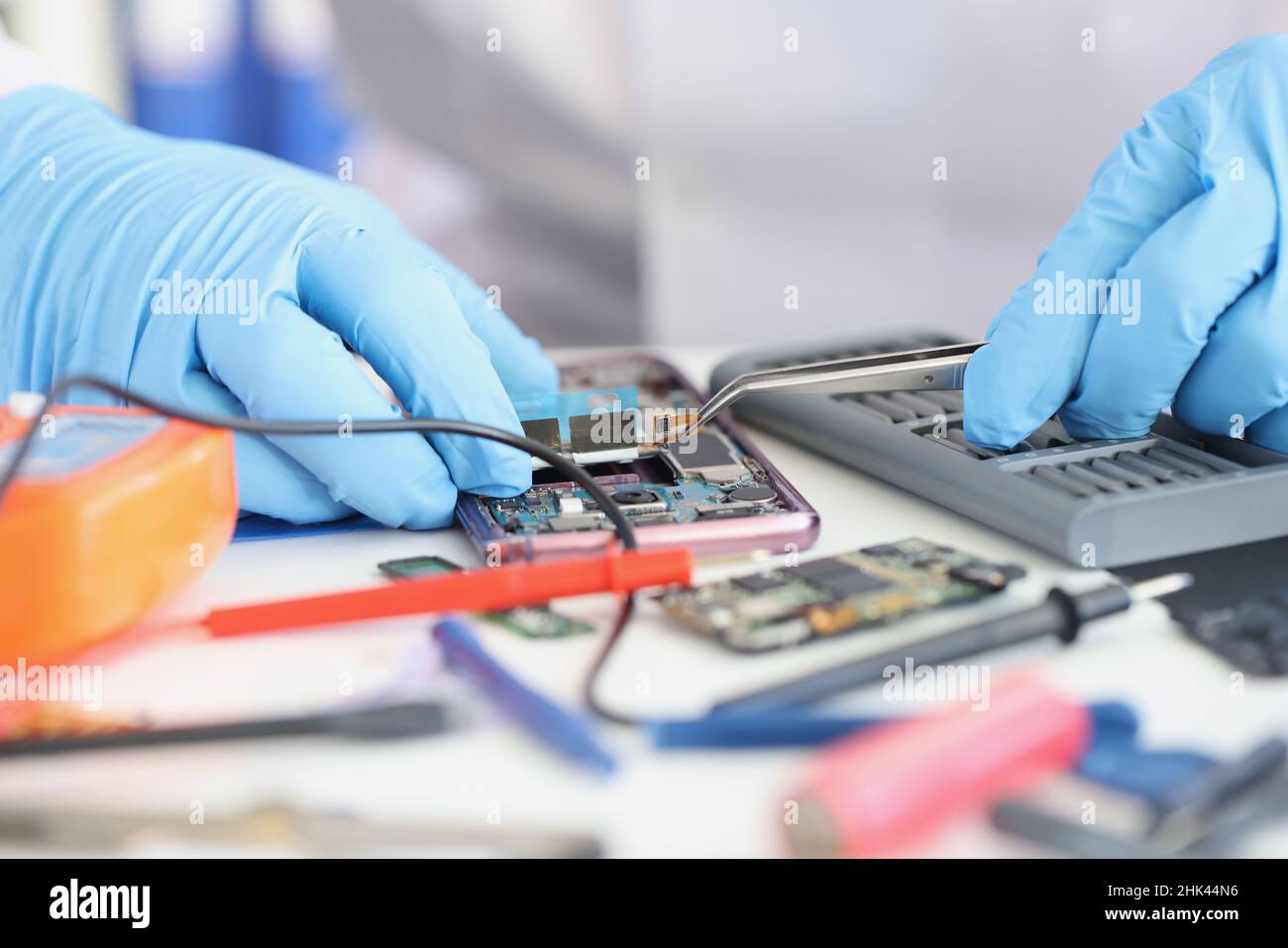 Master repairman inserting microchip into mobile phone closeup Stock Photo