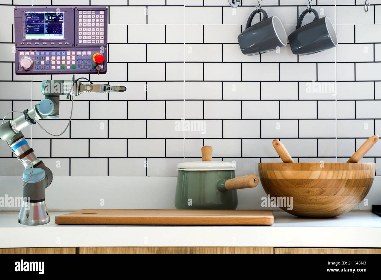 Modern home installed robot arm gripping and control panel for assist resident to work on kitchen room Stock Photo