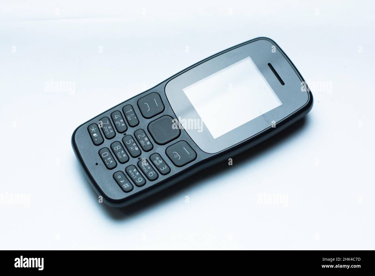 Old style feature phone,copy of Nokia button phone. Feature phone is small lightweight phone just to talk and play simple snake game Stock Photo