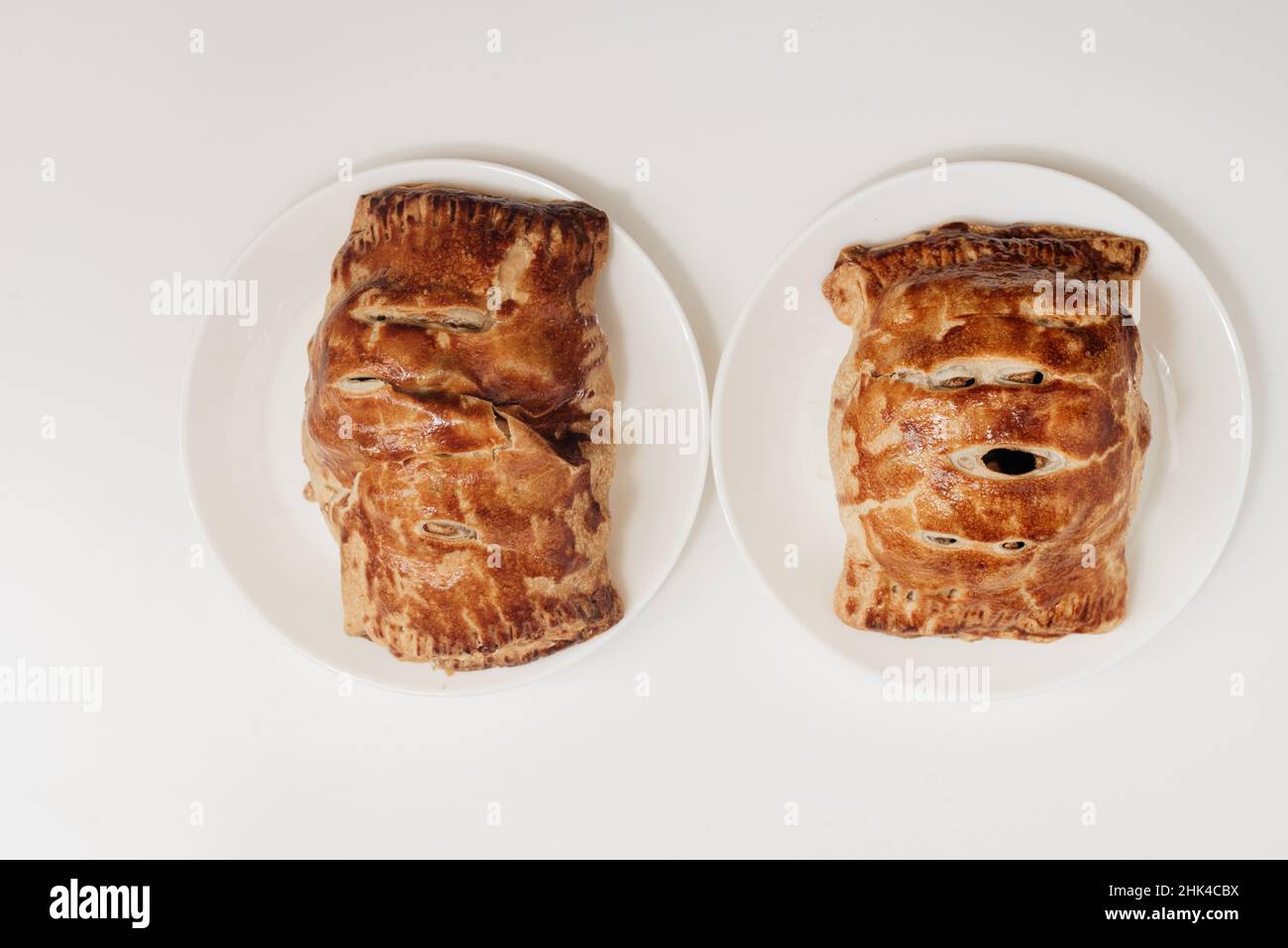Two pieces of apple strudel, homemade, resting on a white surface  Stock Photo