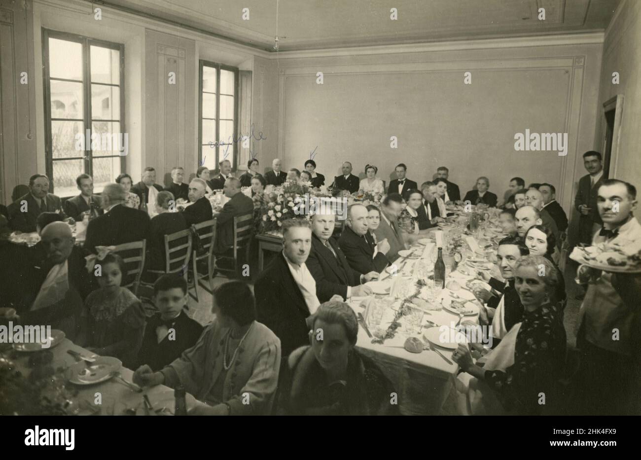 Large group of guests around the table for the wedding, Italy 1940s Stock Photo