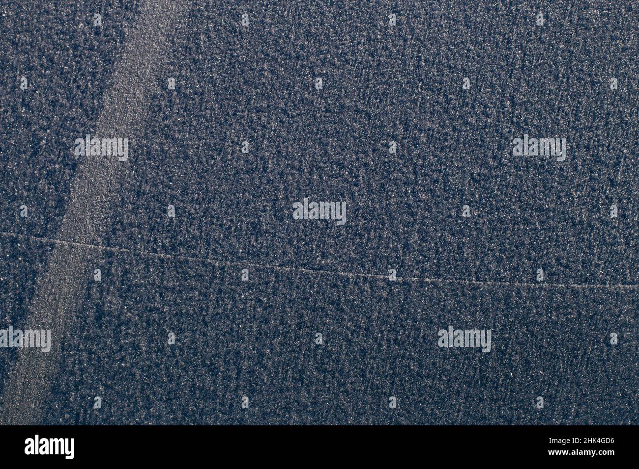 Car's windscreen wiper covered in snow. Frozen window. Stock Photo