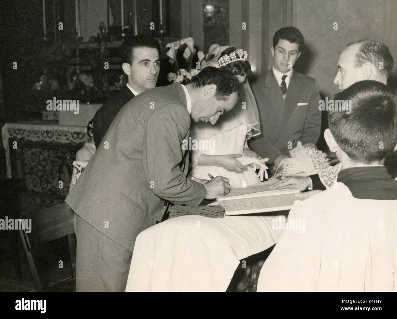 Wedding in Italy during the 1950s: The bride and the groom signing the papers in the church Stock Photo