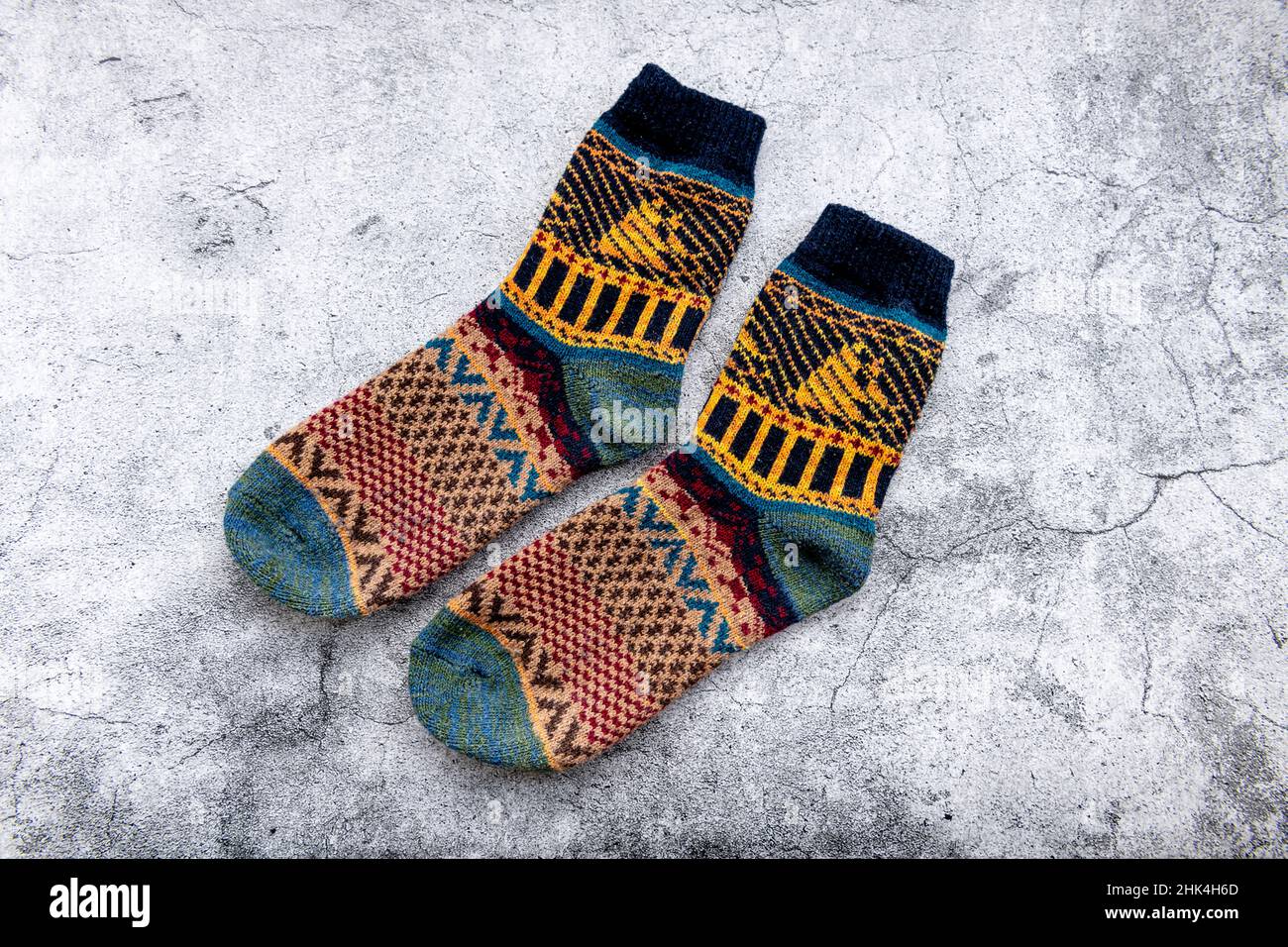 A pair of colorful Winter woolen socks in a grey background. Stock Photo
