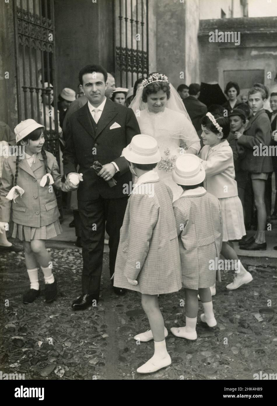 Wedding in Italy during the 1950s: The bride and the groom just married go out of the church with the children Stock Photo