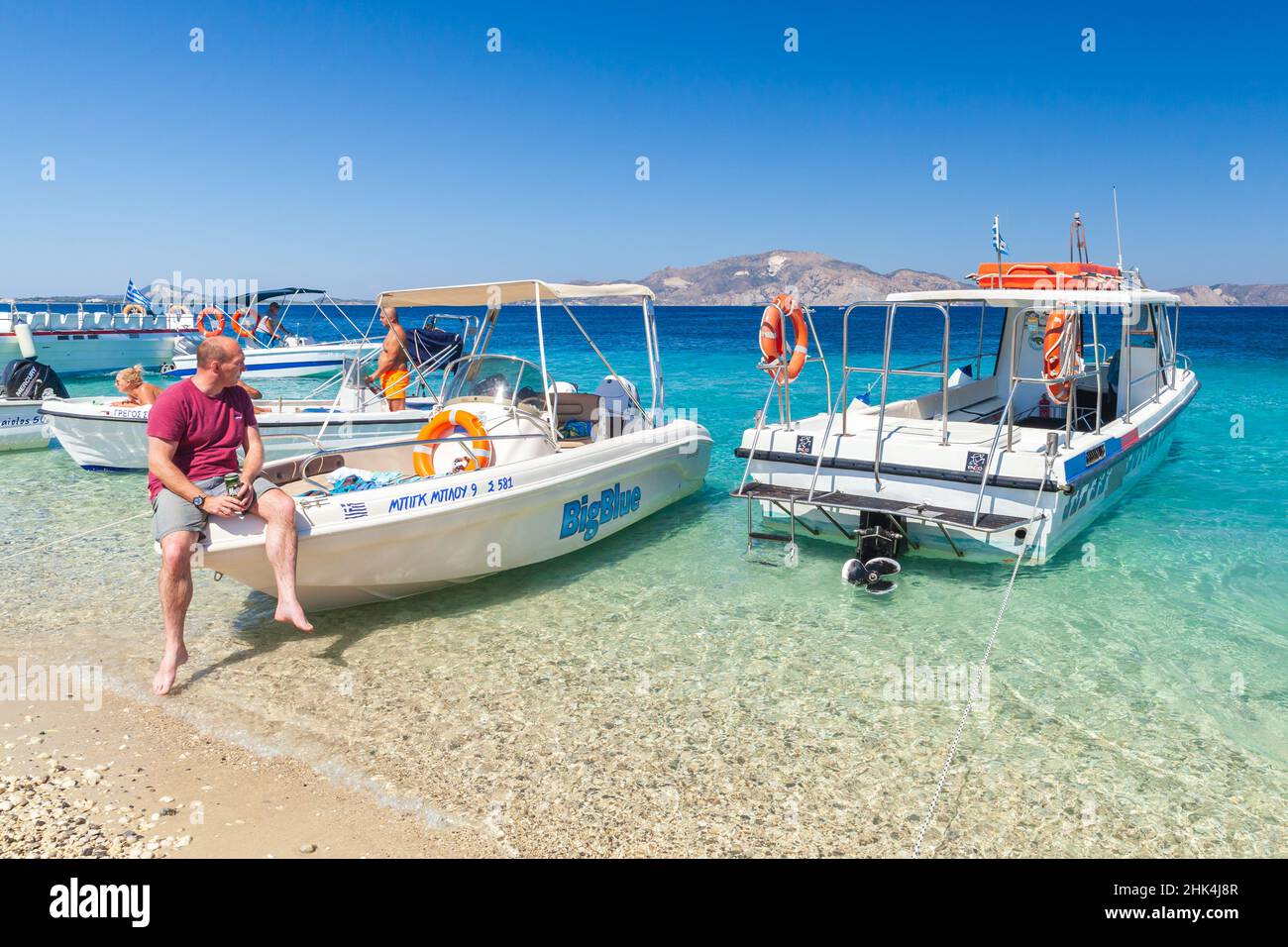 Zakynthos, Greece - August 16, 2016: People rest near pleasure motor boats at the beach. Zakynthos island, Greece Stock Photo
