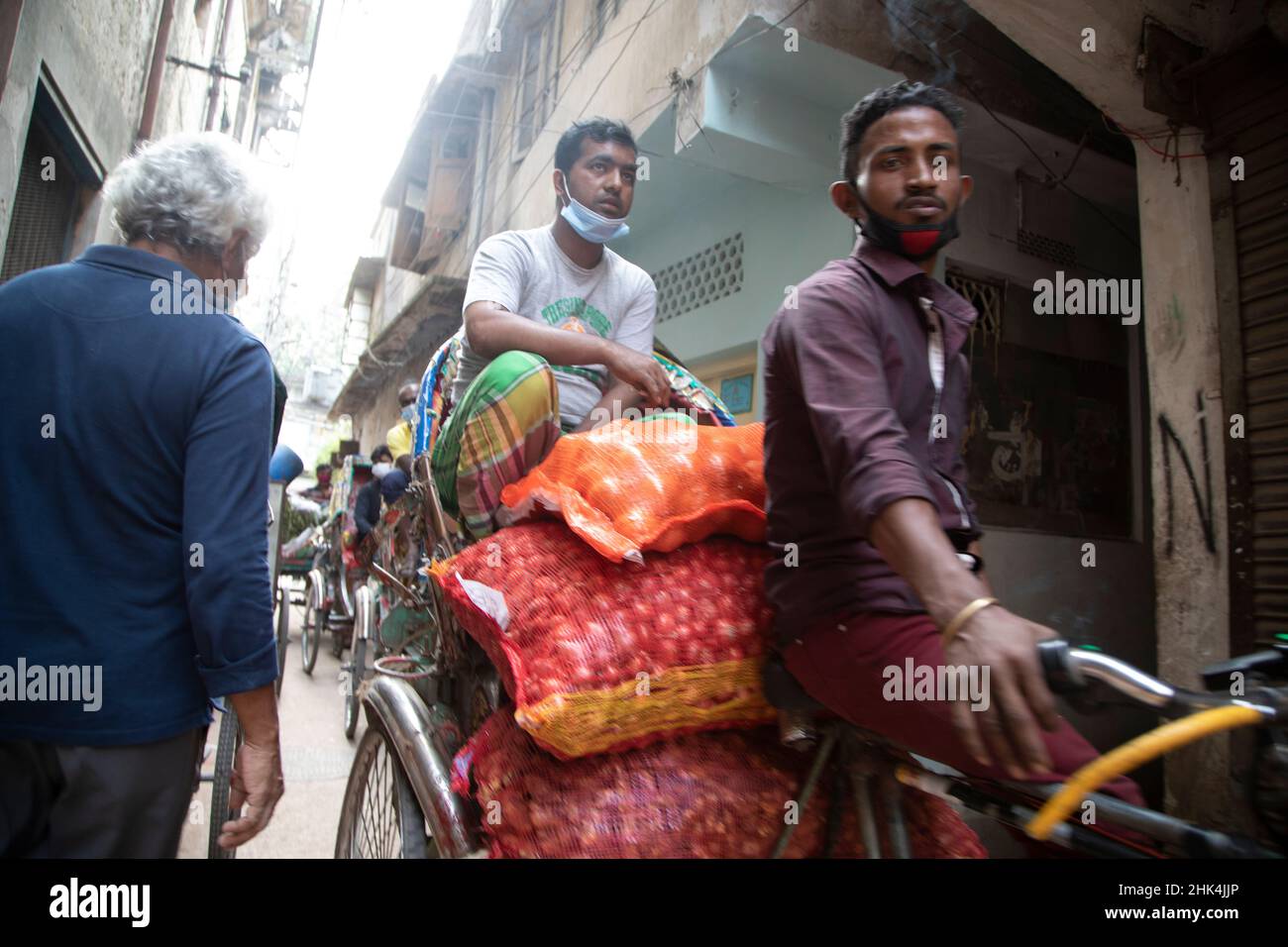 Rickshaw pullers on the streets of Puran Dhaka - Old Dhaka in Bangladesh. The rickshaws are pedal powered tricycles, but used to be pulled by hand, hence 'rickshaw puller'. Nowadays many of the rickshaws are even converted to be powered by electric motor. Stock Photo