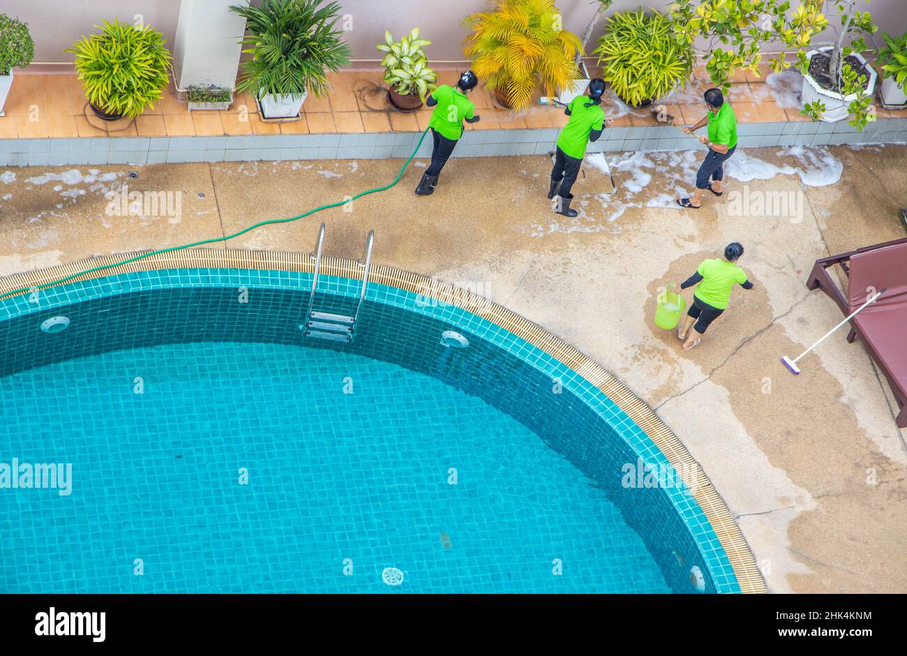 A cleaning crew at work maintaining and tidying up the pool of a