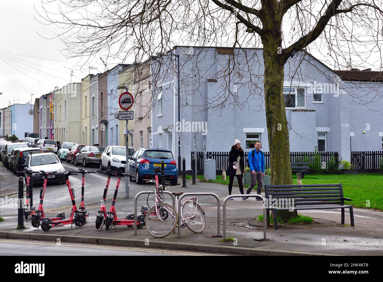 Modes of transport, cars parked both sides of residential road, bike, escooters, walking Stock Photo