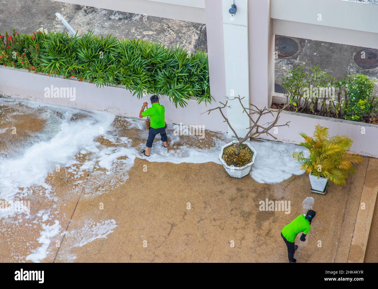 A cleaning crew at work maintaining and tidying up the pool of a condominium or hotel and its associated grounds Stock Photo