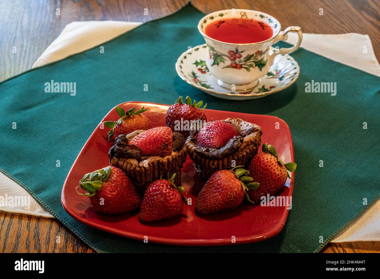 Double chocolate cheesecake cupcakes and strawberries with holly berry ...