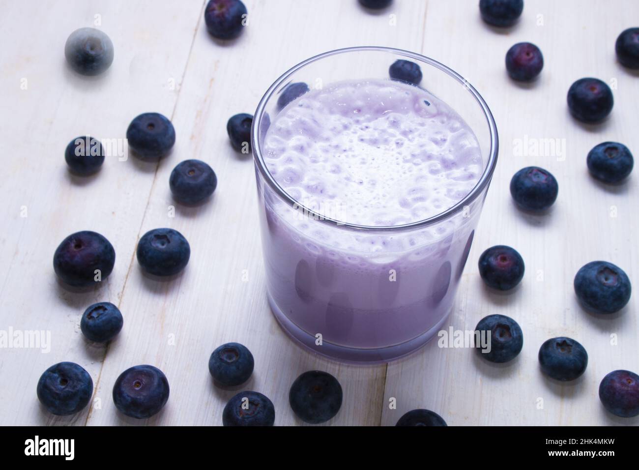 fresh made blueberry milkshake in a glass and some fruits Stock Photo