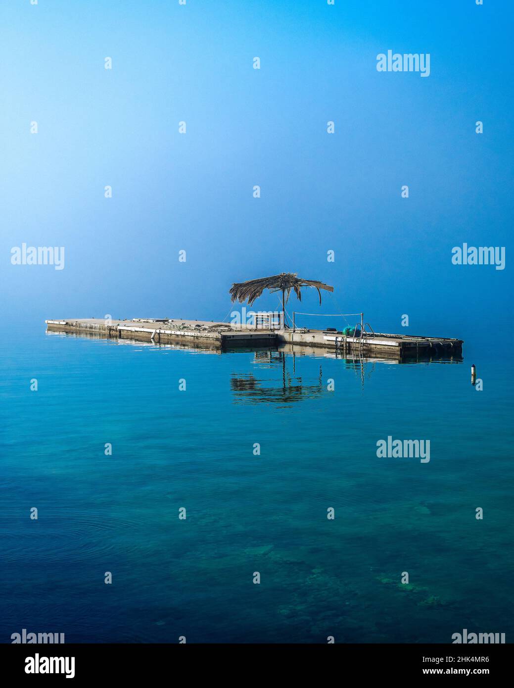 Floating dock in the fog on dead calm sea Stock Photo