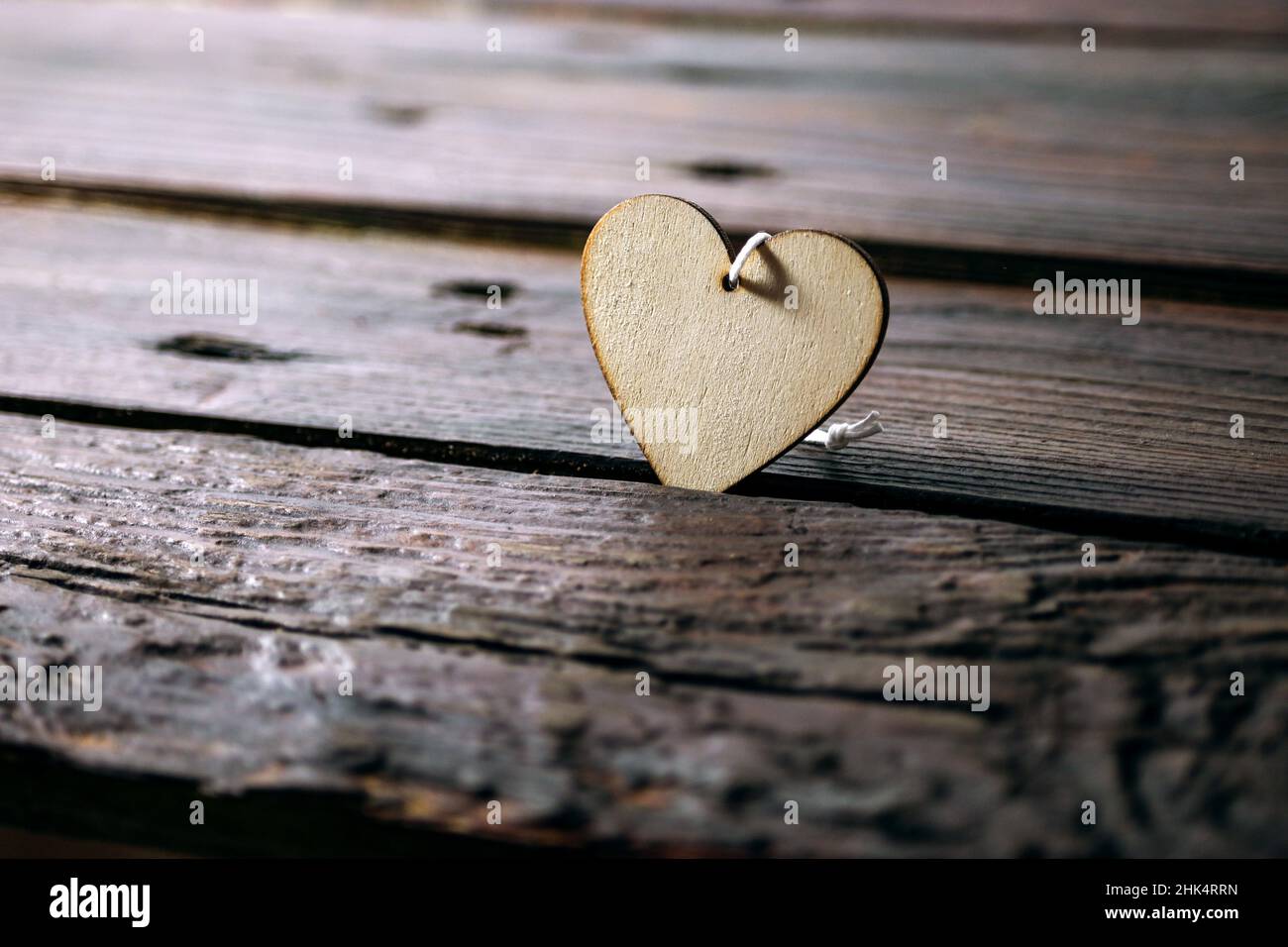 Light wooden heart shape on dark rustic planks, love concept for holidays like valentines, mother's day, father's day and birthday or for everyday lif Stock Photo
