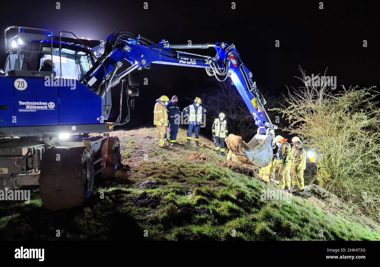 02 February 2022, North Rhine-Westphalia, Herne: Firefighters and THW rescue workers dig up an animal burrow in search of a mongrel dog named 'Jucy'. A small mongrel dog named 'Jucy' has on Tuesday evening in Herne triggered a major operation of the fire department and the Federal Agency for Technical Relief (THW) lasting several hours until the early morning hours. Around 8 p.m., a woman had contacted the fire department by emergency call to report the disappearance of her pet in a badger, fox or rabbit hole. (to dpa 'Large-scale operation because of runaway dog - happy ending for 'Jucy'') Ph Stock Photo