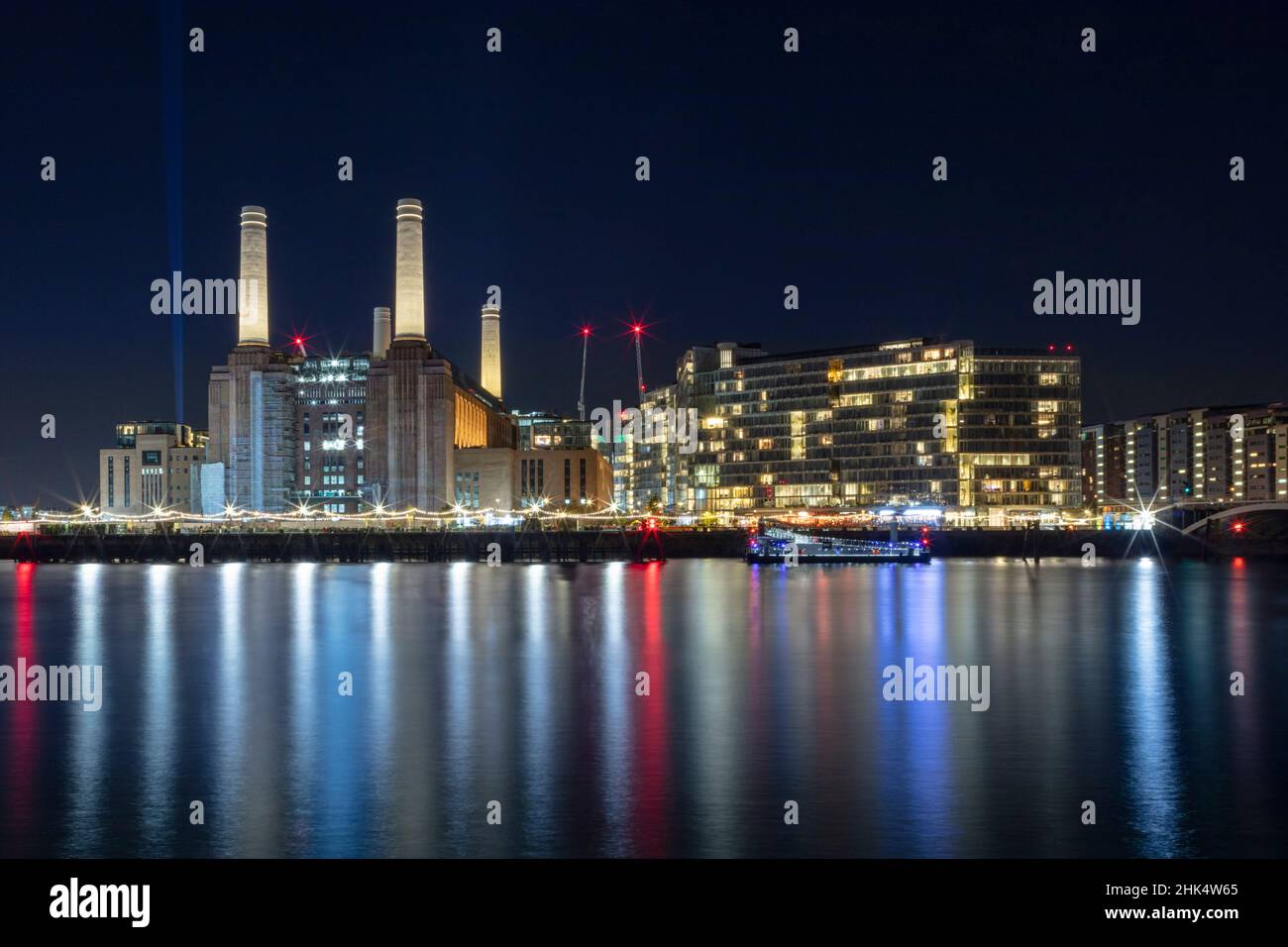 The newly renovated Battersea Power Station and apartments, night shot, reflected in River Thames, Nine Elms, Wandsworth, London, England Stock Photo