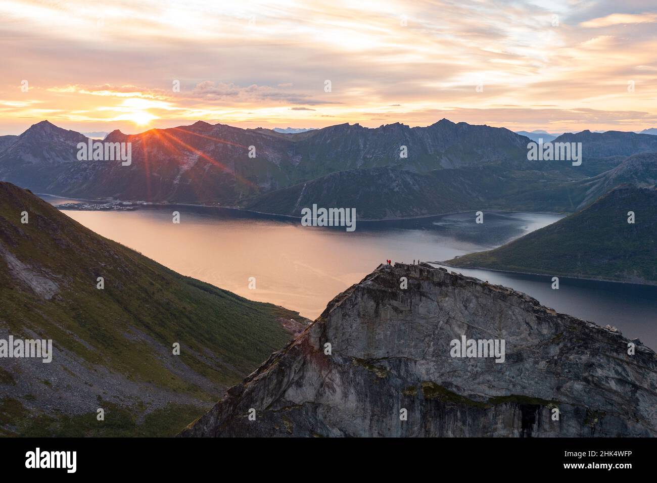 People admiring the sky at dawn standing on mountain top above the fjords, Senja island, Troms county, Norway, Scandinavia, Europe Stock Photo