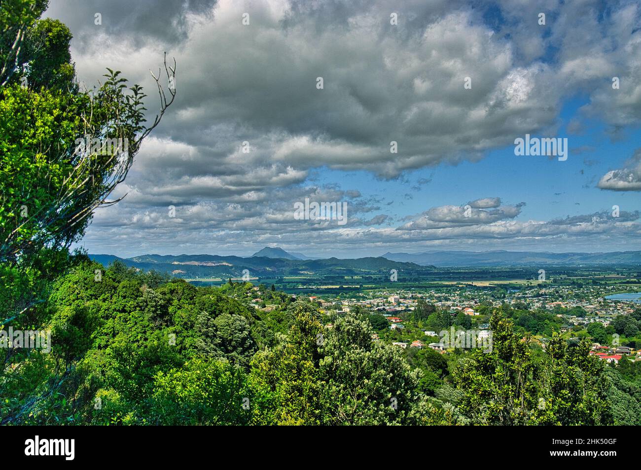 View of the town of Whakatane on the Bay of Plenty, North Island, New Zealand, with high hills and a volcano in the background Stock Photo