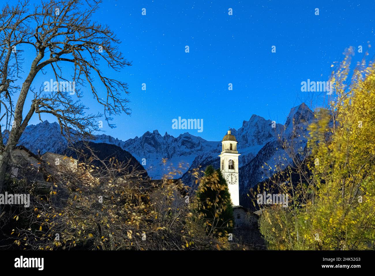 Starry night on the snowcapped Piz Badile and Cengalo peaks framed by the bell tower, Soglio, Graubunden Canton, Switzerland, Europe Stock Photo