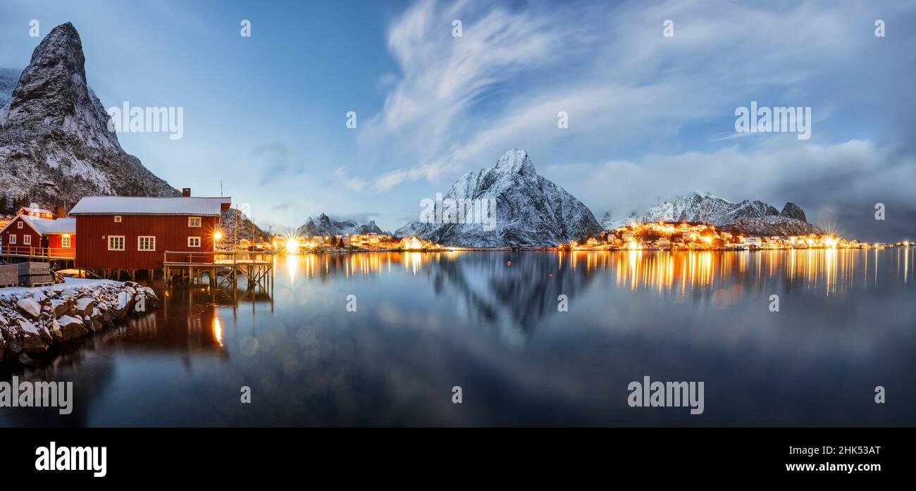 Olstind mount and traditional red fishermen's cabins mirrored in the cold sea at dusk, Reine, Nordland, Lofoten Islands, Norway, Scandinavia, Europe Stock Photo