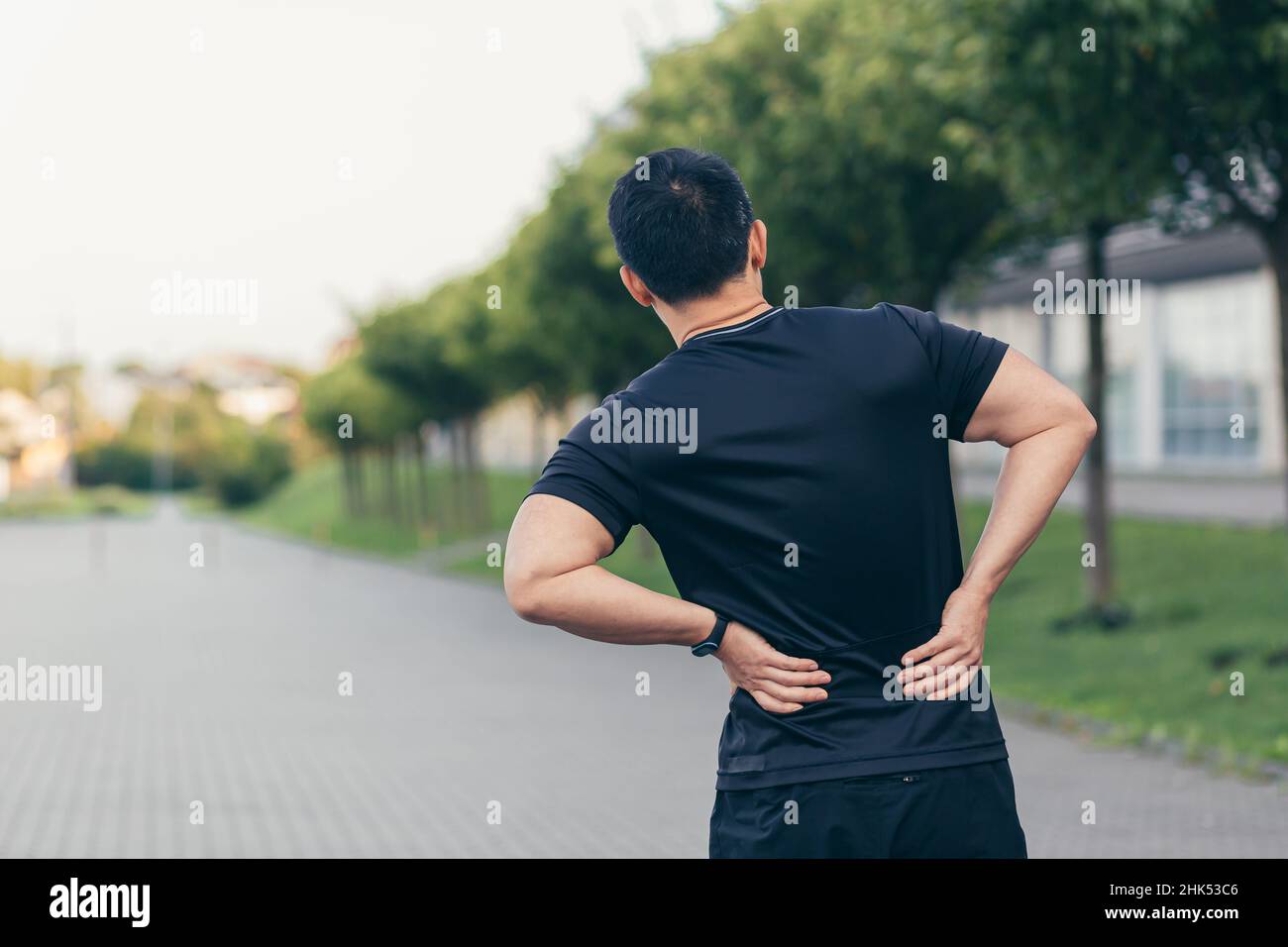 Asian man holding back pain after running and fitness Stock Photo Alamy