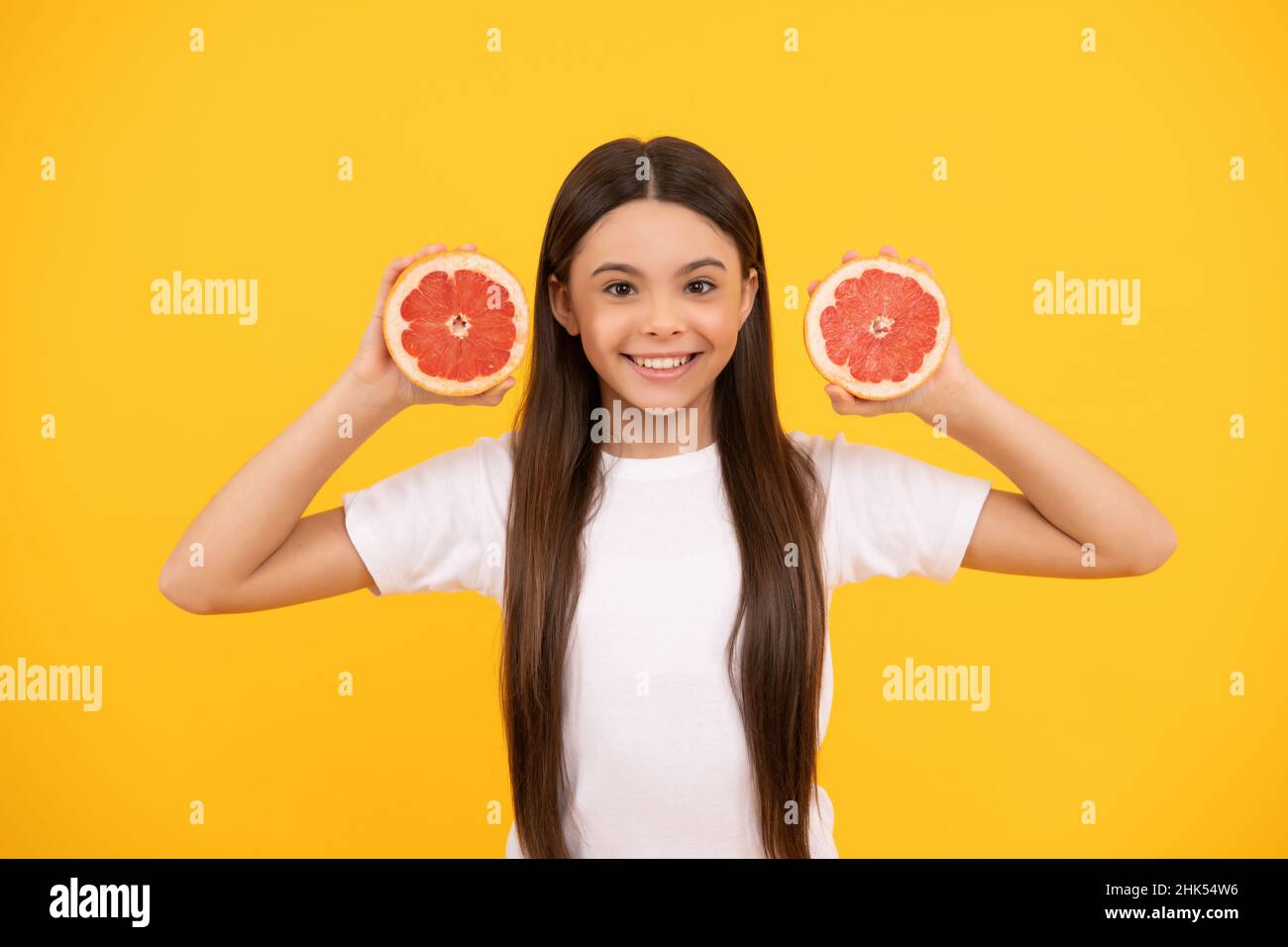 happy teen girl with grapefruit on yellow background, diet Stock Photo
