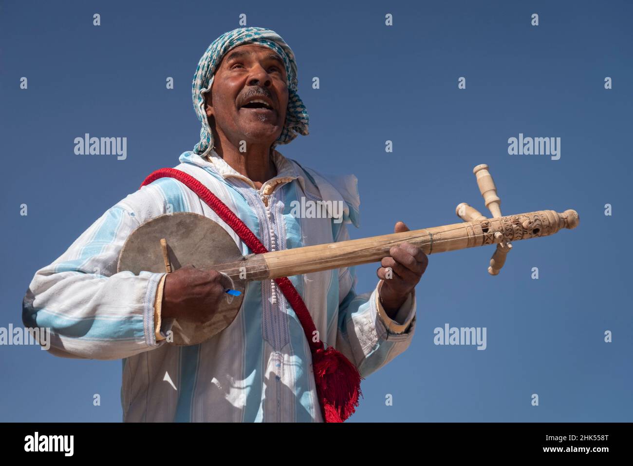 Moroccan man in traditional dress playing a traditional Gimbri instrument, Ouarzazate, Atlas Mountains, Morocco, North Africa, Africa Stock Photo