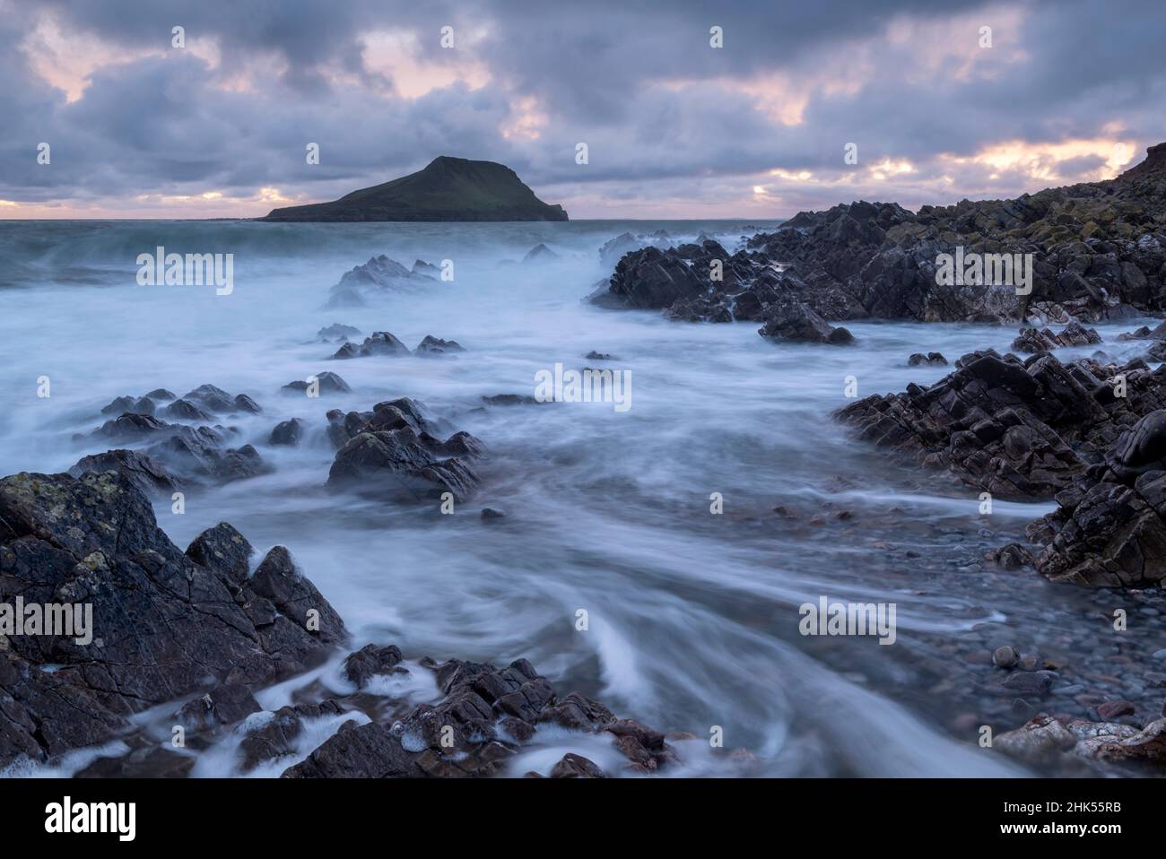Worm's Head at high tide from the rocky seashore near Rhossili, Gower Peninsula, Wales, United Kingdom, Europe Stock Photo