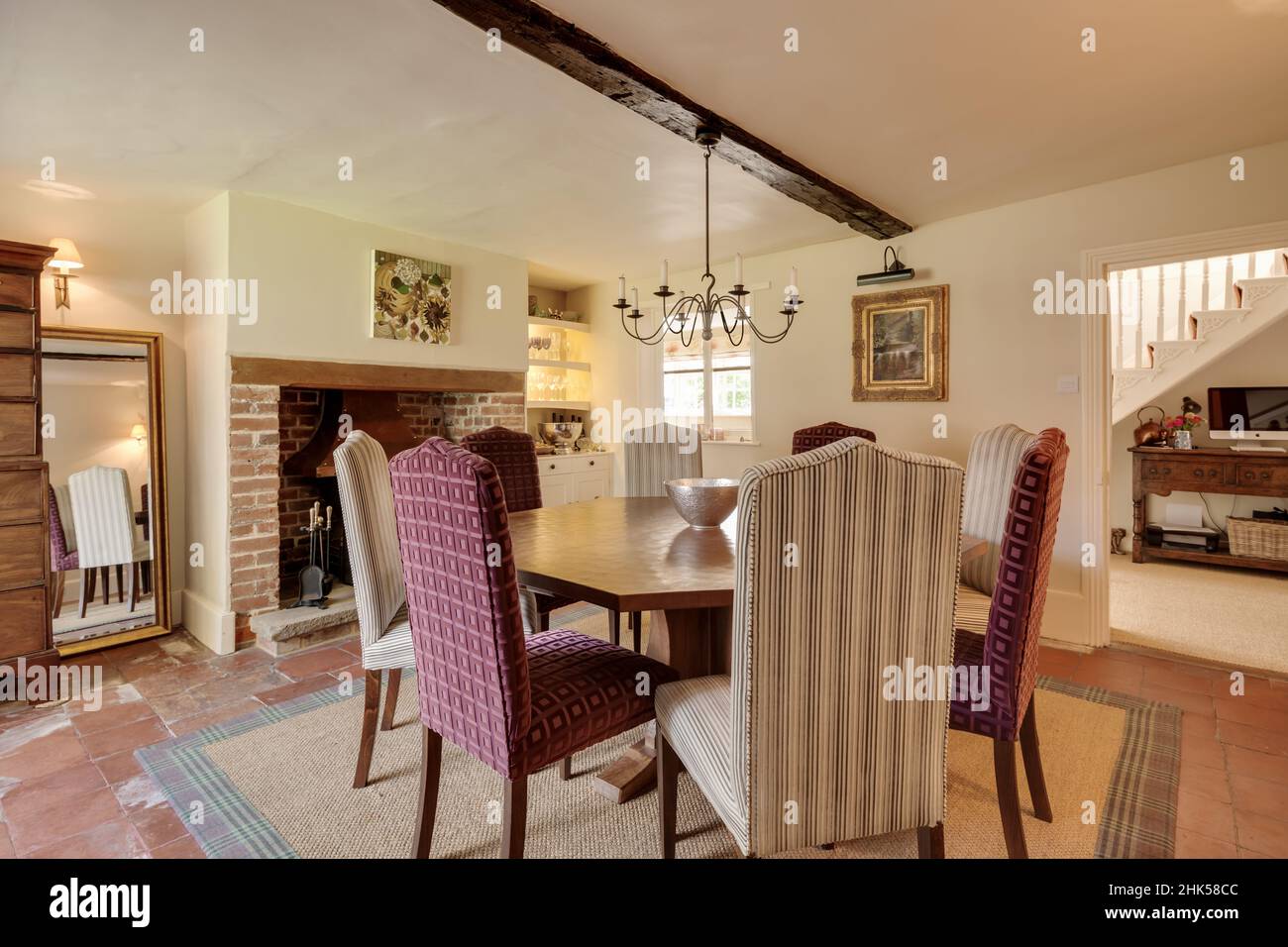 Linton, Cambridgeshire - August 31 2017: Dining room with table and chairs within traditional old home including original brick fireplace. Stock Photo