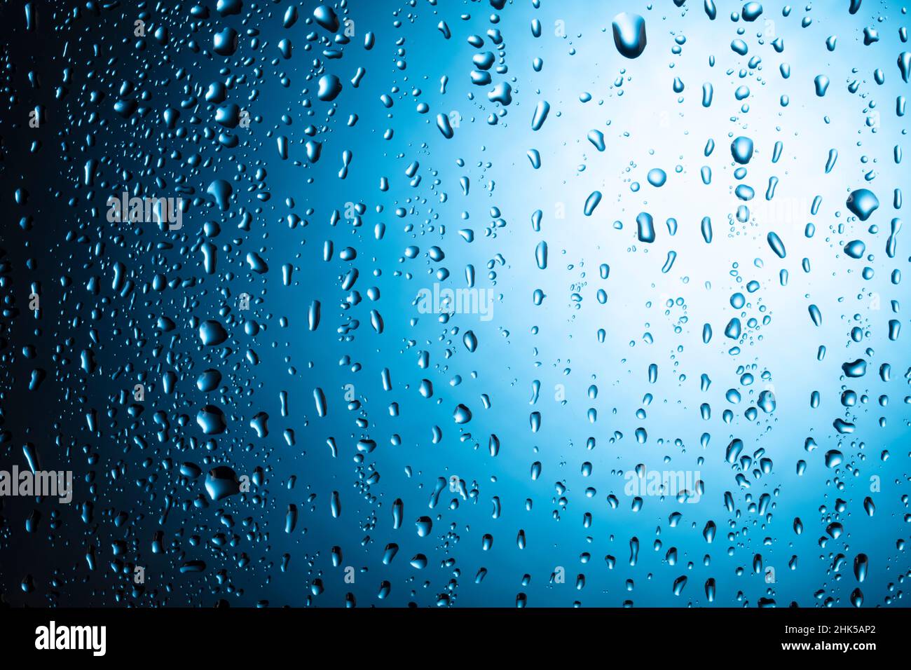Water drops close-up on a blue glass background Stock Photo - Alamy