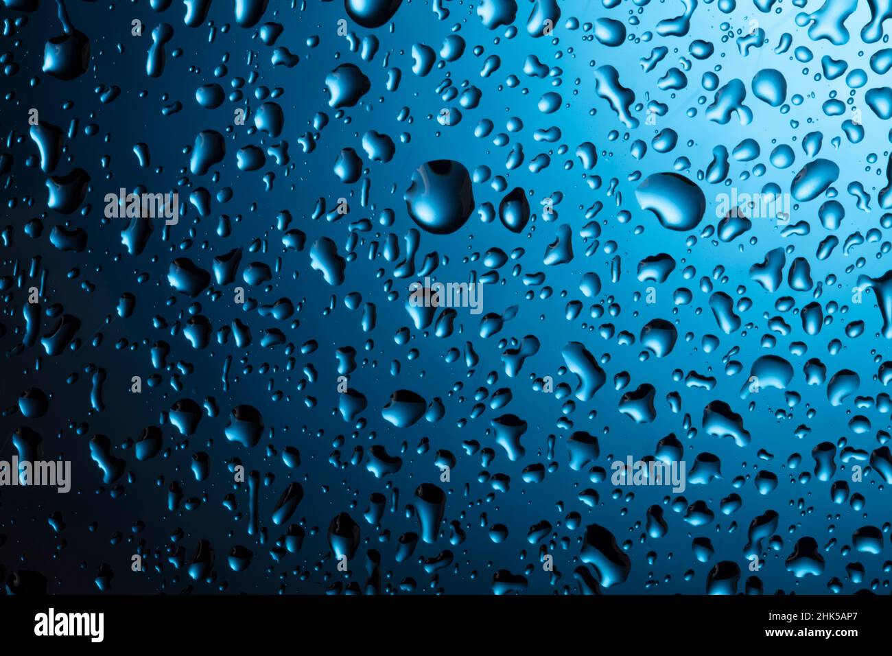 Water drops close-up on a blue glass background Stock Photo - Alamy