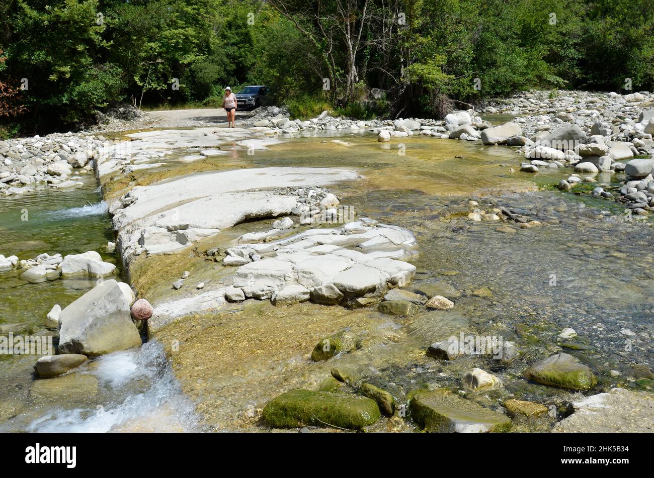 Plaka, Greece - June 30, 2021: Unknown woman on the river bank where the road became impassable in the National Park of Tzoumerka- Peristeri- Arachthos Stock Photo