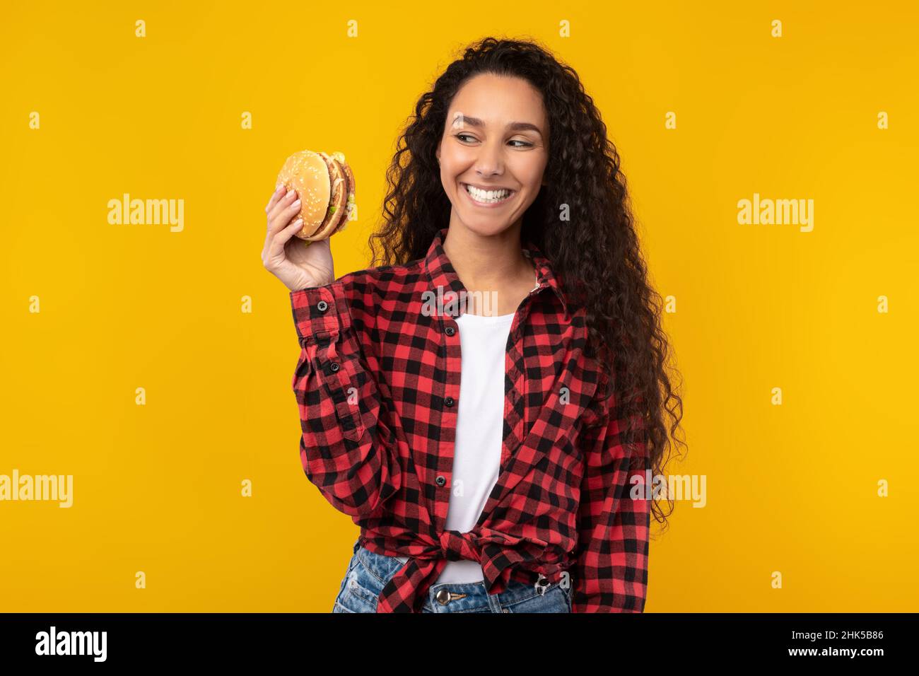 Funny Young Lady Holding Burger At Studio Stock Photo