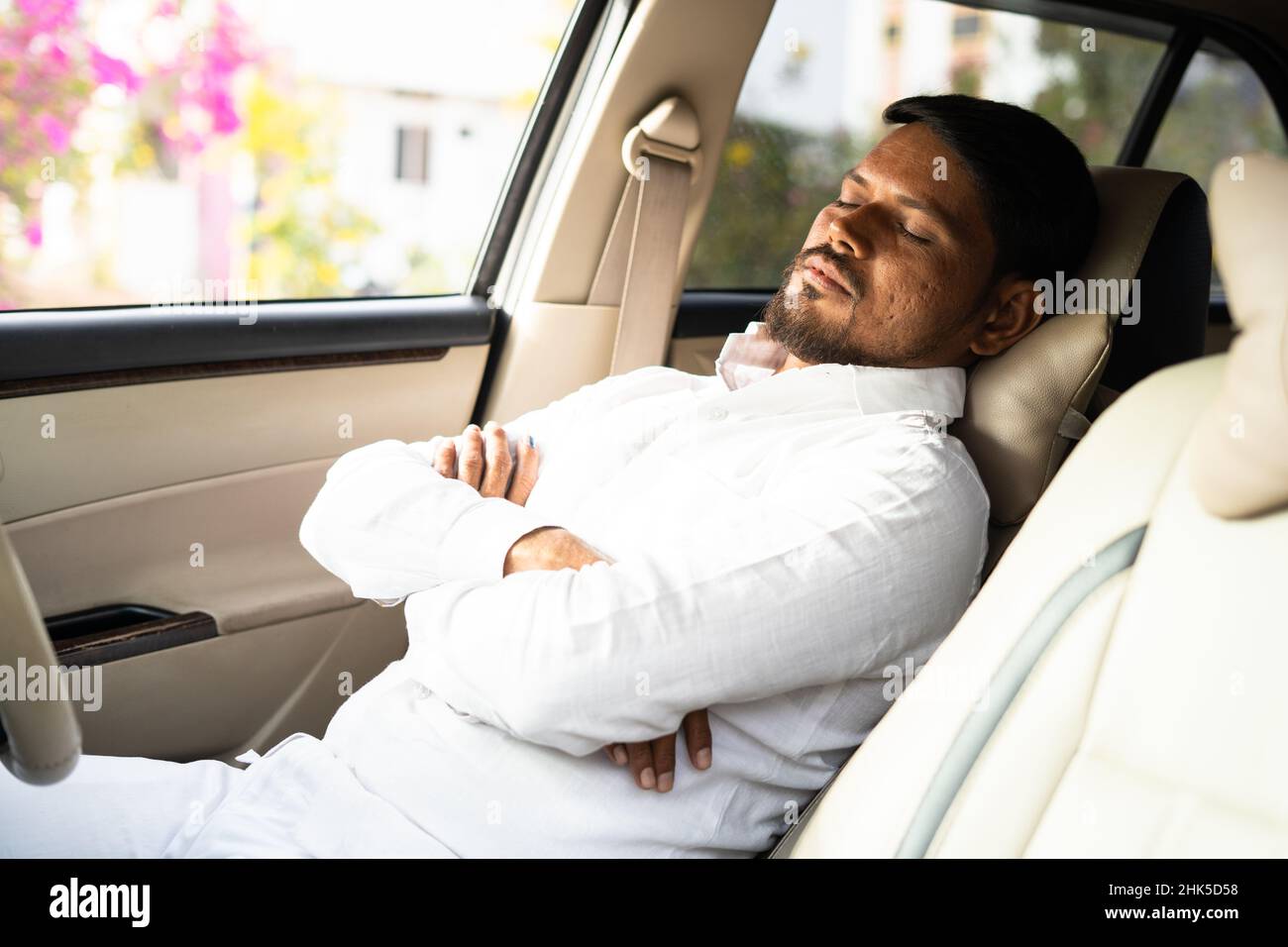 tired cab driver resting or sleeping by pushing car seat during break time - concept of overworked, exhausted and low business or no passengers Stock Photo