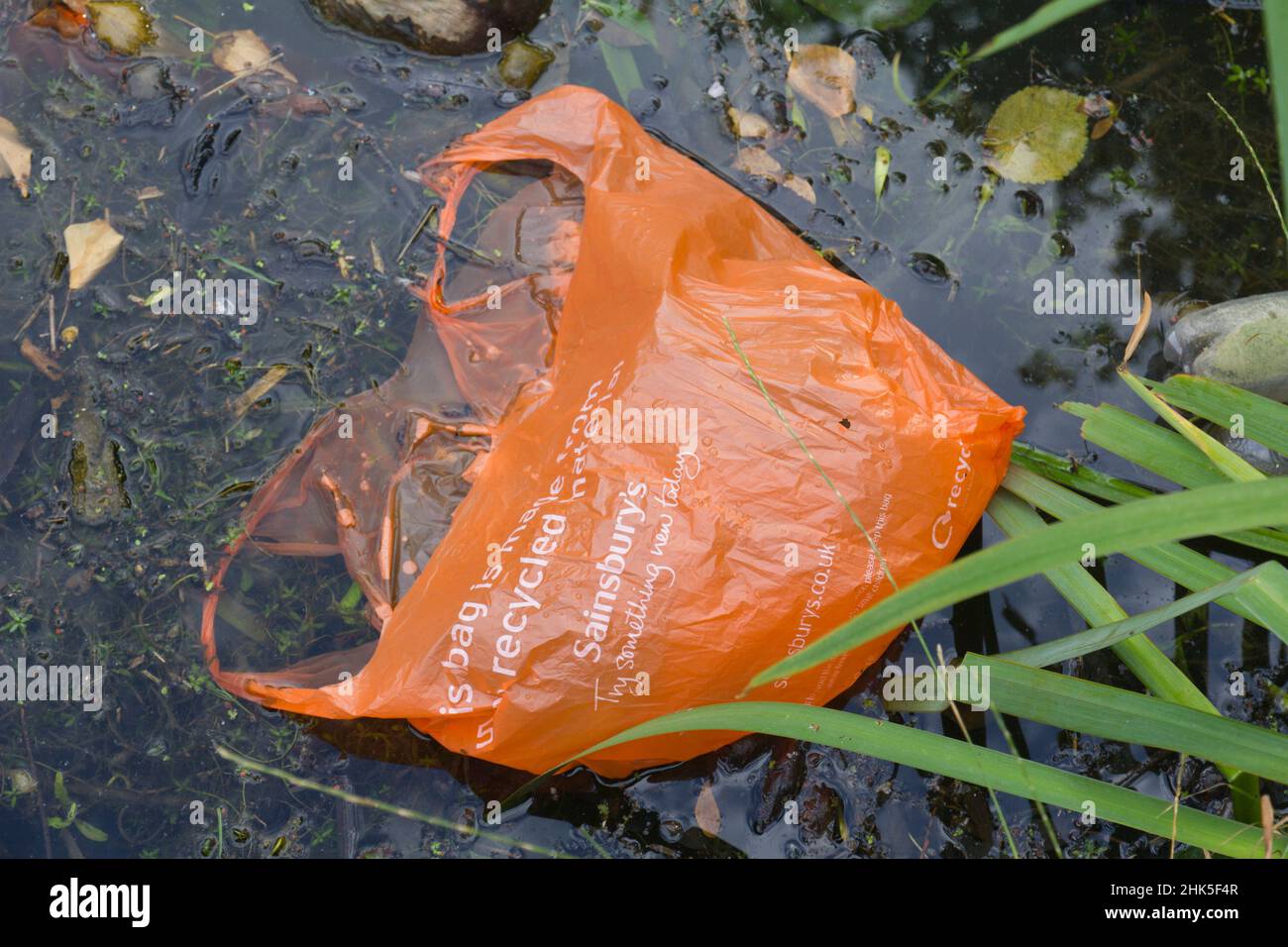Now here's a grim joke - the bag is exhorting us to recycle it... presumably that doesn't mean chucking it in Oxford Canal! Stock Photo