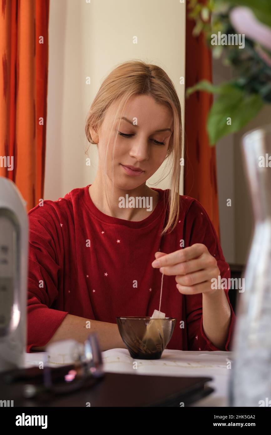 Woman making tea in the kitchen Stock Photo