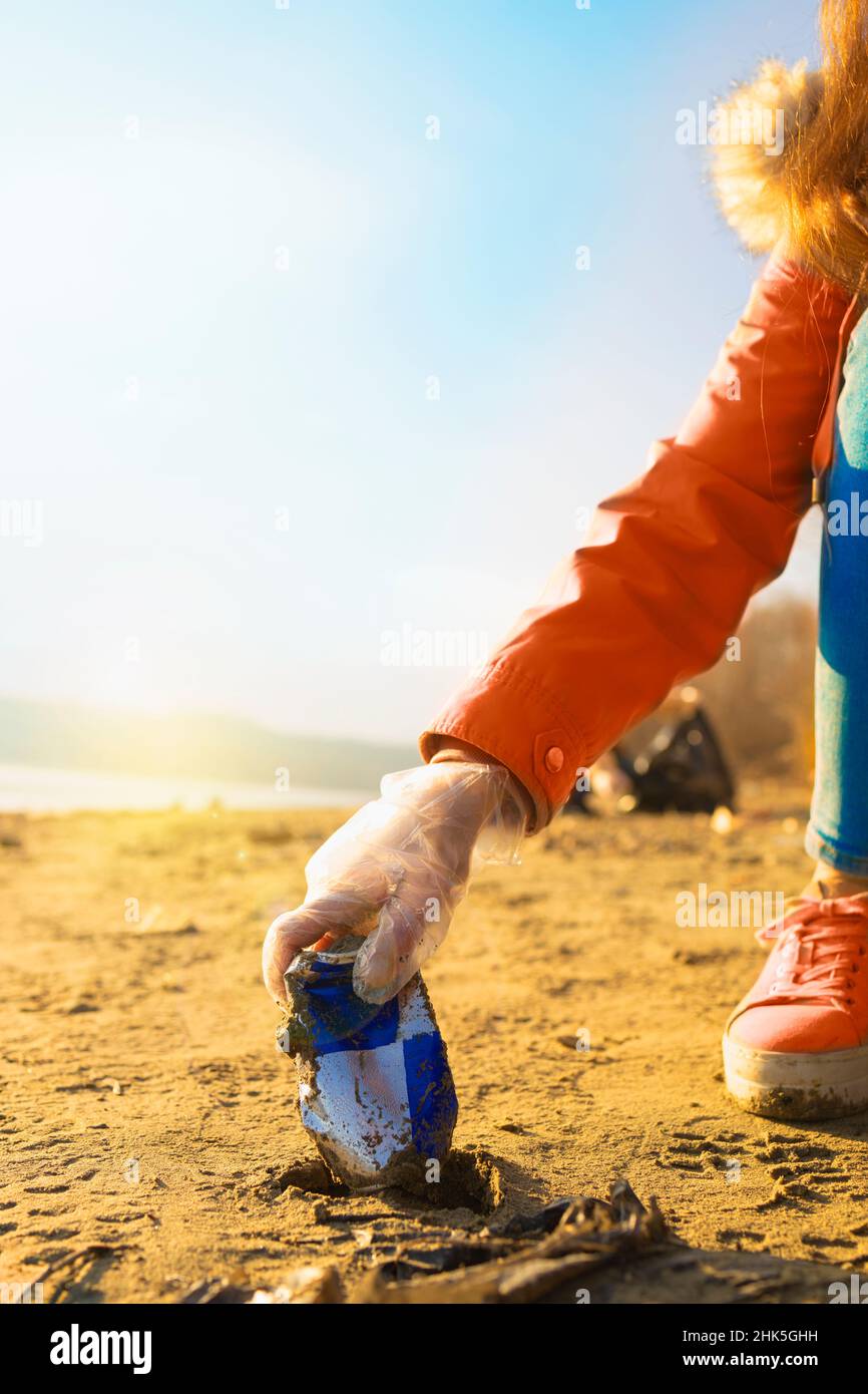 Detail of an aluminium can being picked by a volunteer from the beach Stock Photo