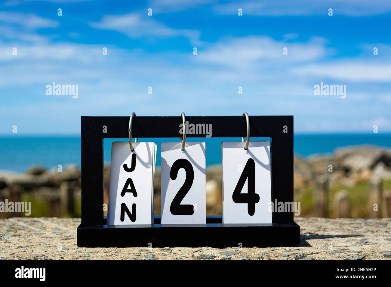 Jan 24 calendar date text on wooden frame with blurred background of ocean. Calendar concept Stock Photo